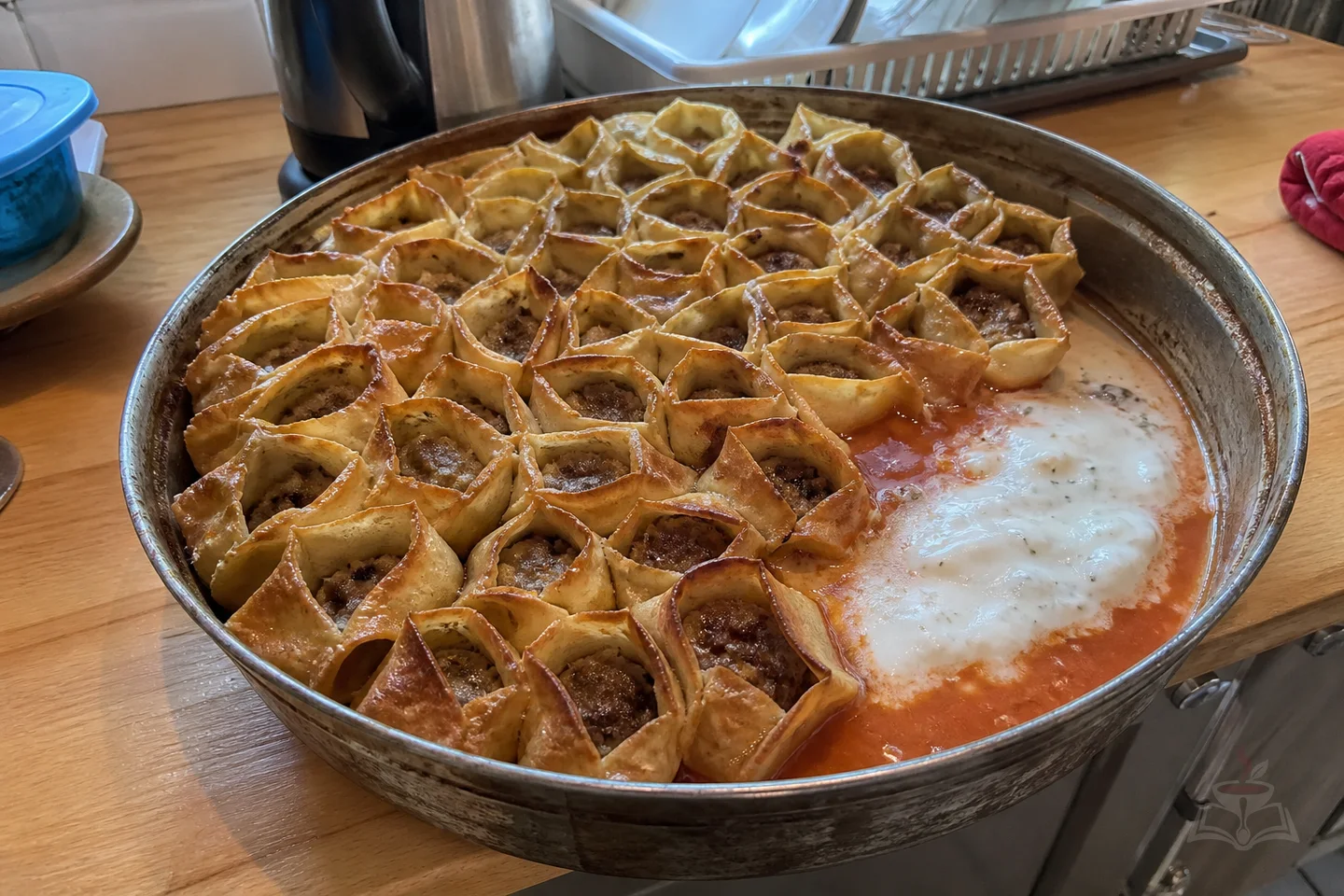 Armenian baked manti dumplings in a honeycomb pattern with tomato and matsoni sauces