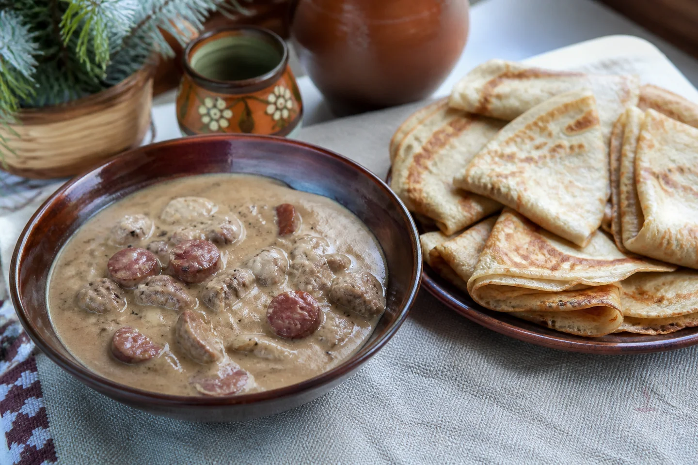 Belarusian machanka pork gravy with sausage and a stack of thin pancakes