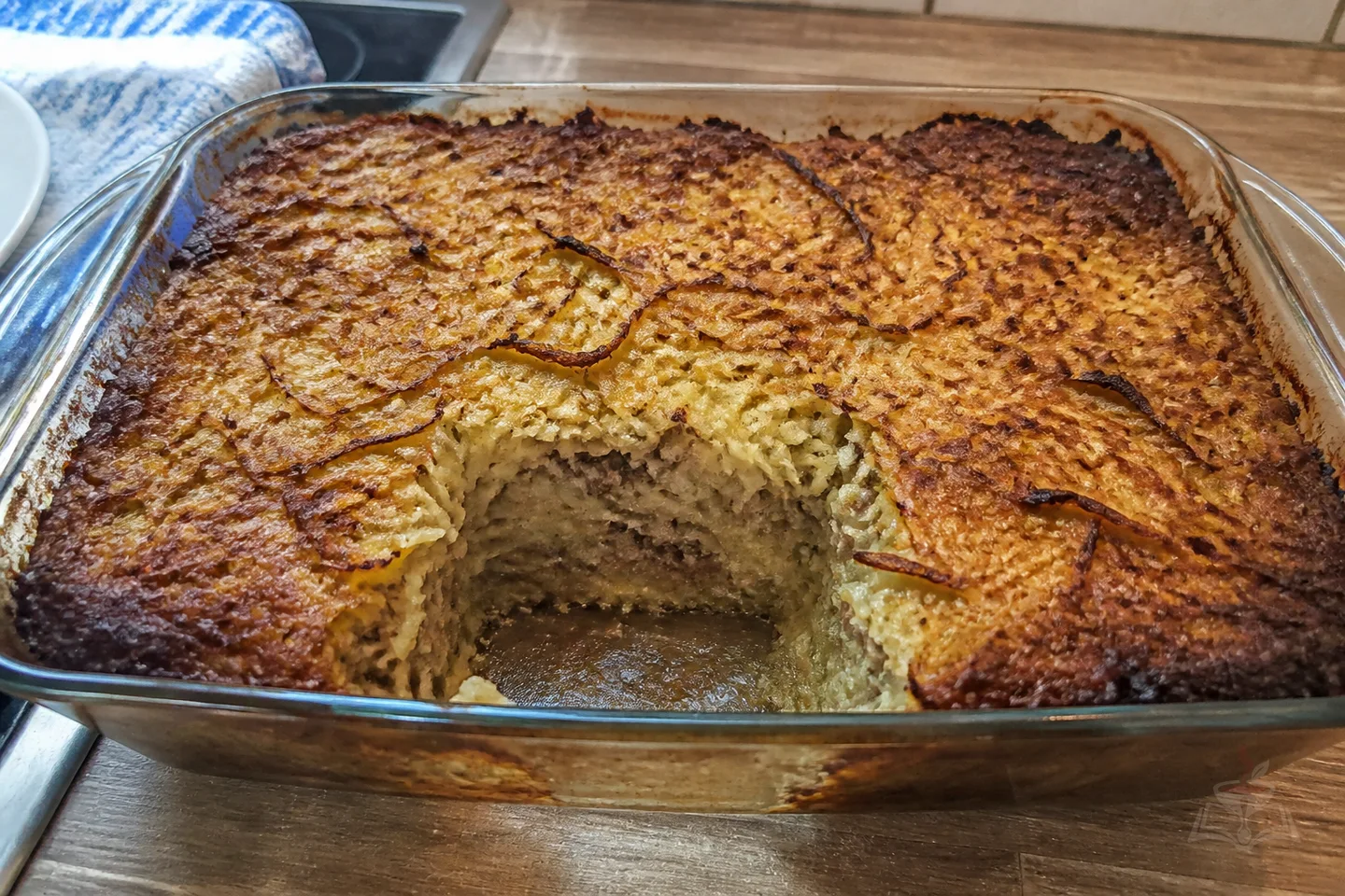 Belarusian potato babka casserole with a browned crust and sour cream