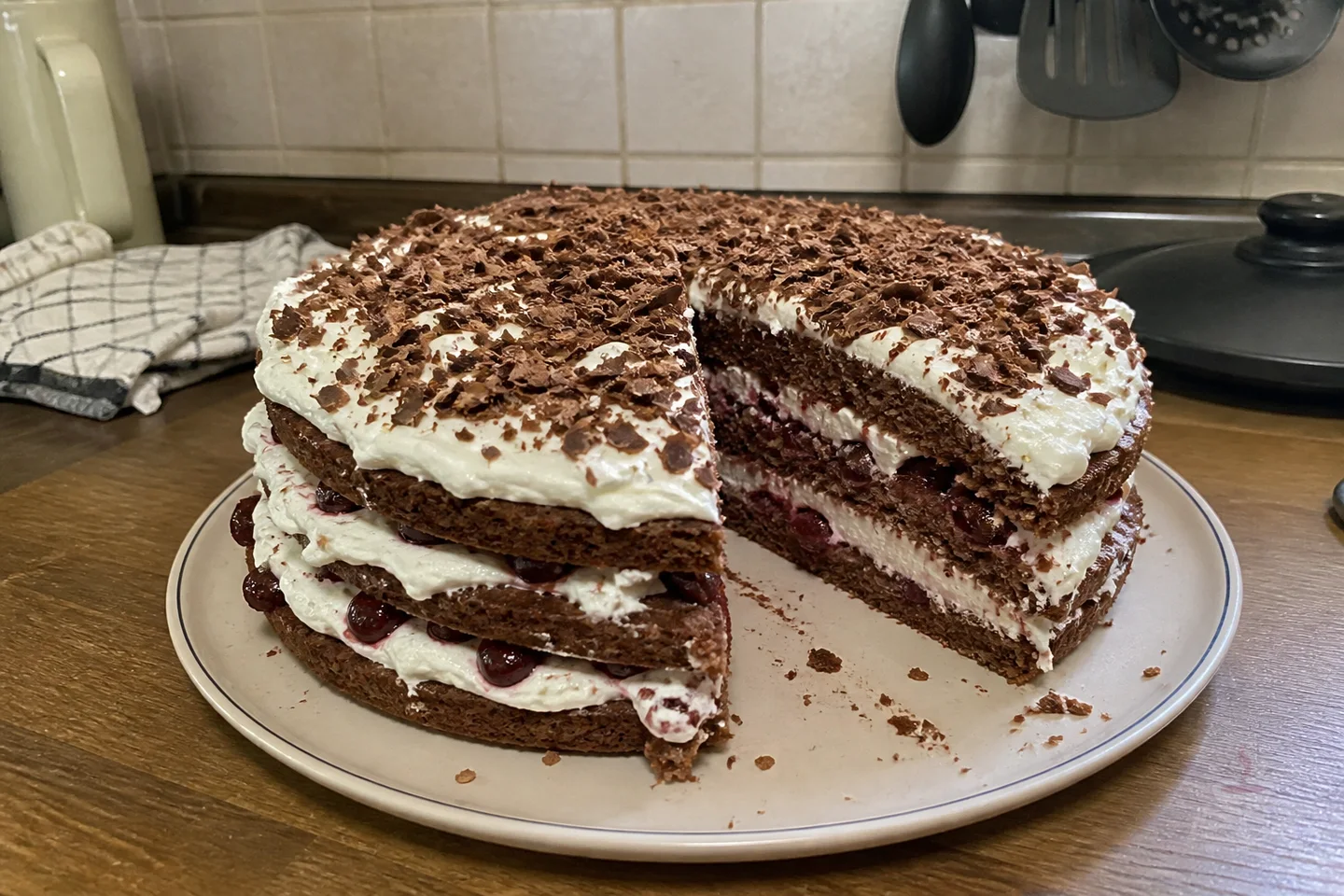Black Forest cake slice with chocolate sponge, whipped cream, sour cherries, and chocolate shavings
