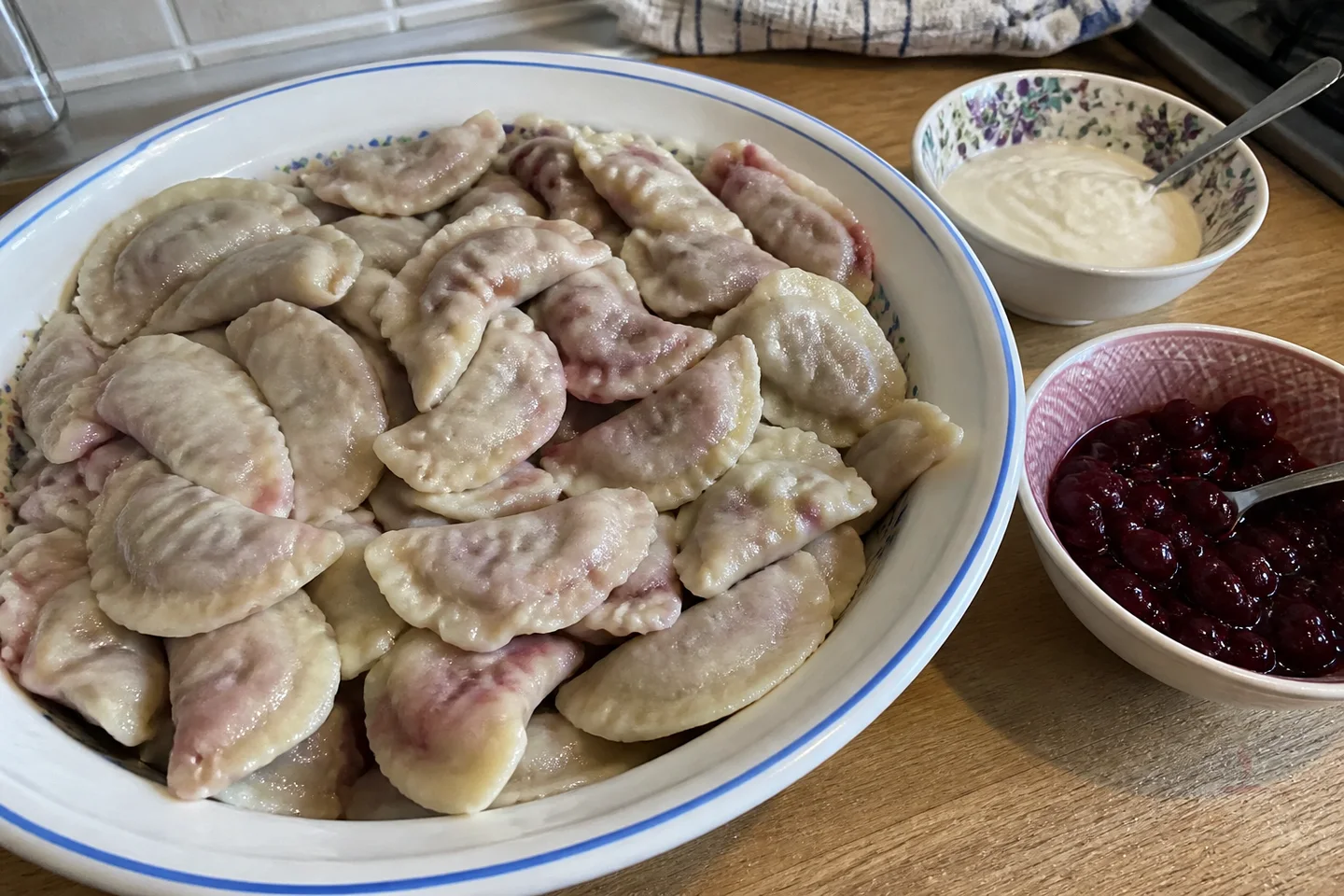 Ukrainian cherry varenyky with sour cream, butter, and fresh cherries