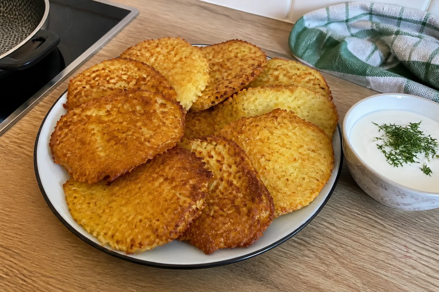 Crispy potato draniki served with sour cream and fresh dill