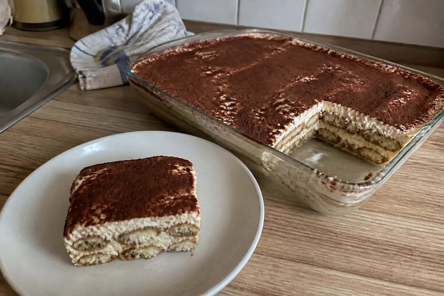 Classic Italian tiramisu with visible coffee-soaked ladyfinger and mascarpone layers