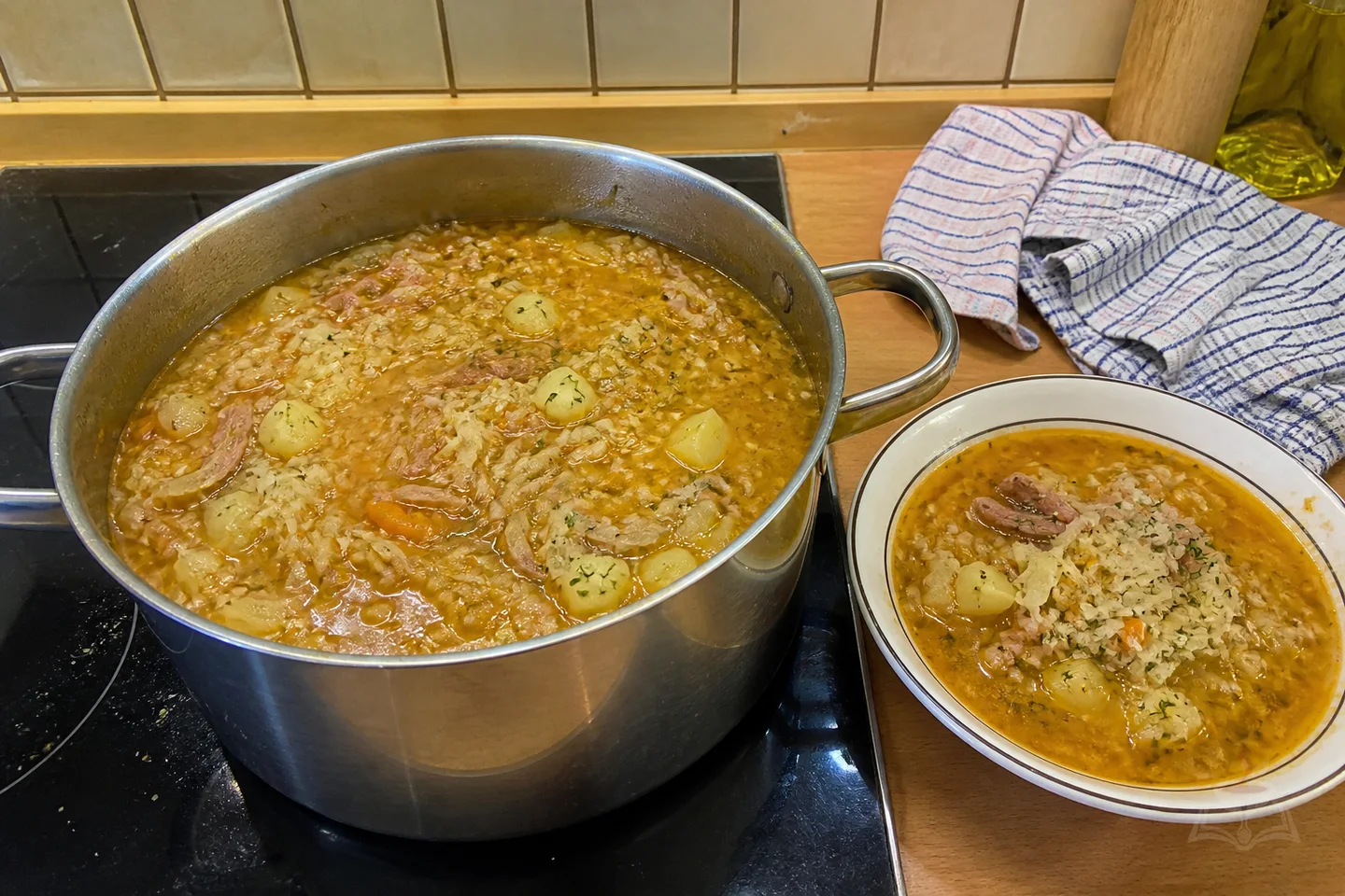 Ukrainian kapusnyak soup with smoked pork ribs, sauerkraut, potatoes, millet, and herbs