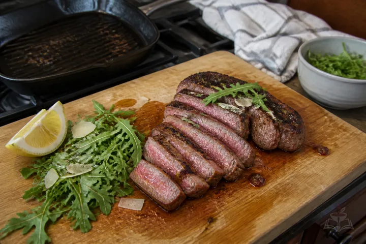 Tuscan sliced tagliata steak over arugula with Parmesan and lemon